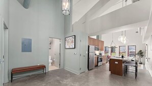 A spacious kitchen with high ceilings, a central island, and modern appliances. - Designer Loft Penthouse in the Heart of Downtown (Pittsburgh)