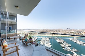 A balcony with a view of a marina and cityscape.
