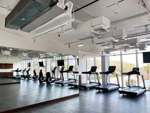 A gym with treadmills, stationary bikes, and exercise equipment. - Cozy DIFC Duplex w/ Burj View, Pool and Gym (Dubai)