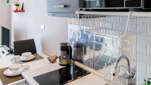 Eine moderne Küche mit Mikrowelle, Wasserkocher und Geschirrgestell.
