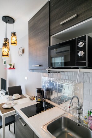 Een microgolfoven, een kookplaat, kookgerei, borden en bestek