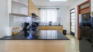 A modern kitchen with a central island, stainless steel appliances, and wooden cabinets. - Spacious 3-bedroom apartment with WiFi, swimming pool in vibrant Tatu City (Tatu City)