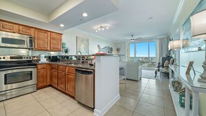 A spacious kitchen with modern appliances, wooden cabinets, and a large island. - ESCAPE TO THE INDIES CONDO IN FORT MORGAN ALABAMA! (Gulf Shores)