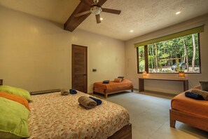 Une chambre à coucher avec un lit, un banc et une fenêtre donnant sur des arbres.
