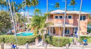 A two-story house with a pool, surrounded by palm trees and a well-maintained garden. - Walk To Beach / Waterfront / Heated Pool /  Pelican  Key | RESIDENCES (Lauderdale-by-the-Sea)