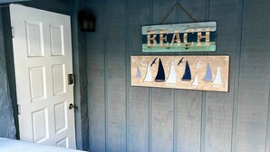 Una puerta con un cartel que dice 'BEACH' y otro cartel más abajo con barcos de vela.