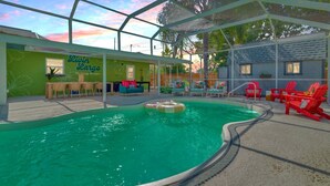 An indoor pool area with a covered seating area, a sign reading "Livin' Cargo," and a pool with a floating ring.