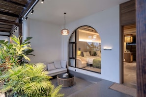 A modern interior with a large arched window, a sofa, a round table, and a hanging light fixture. - Dali Qingmai Seaview Resort (Dali)