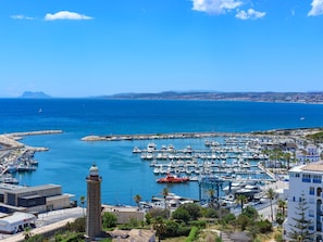 Un port de plaisance avec des bateaux, un phare et une ville côtière.