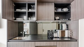 A modern kitchen with wooden cabinets, a built-in oven, a toaster, and a kettle. - Blueground | Wiedikon, AC & w/d, nr museums (Zurich)