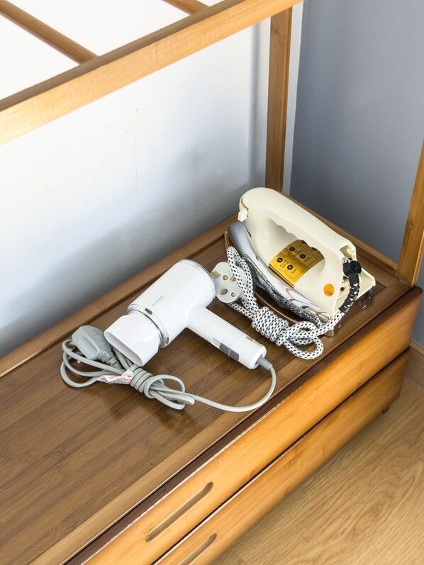 A hairdryer and a telephone on a wooden shelf. - MayaBay Residence by Sleepy Bear (Banting)