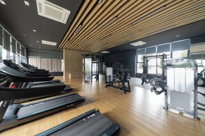 A modern gym with treadmills, weight machines, and a wooden ceiling. - MayaBay Residence by Sleepy Bear (Banting)