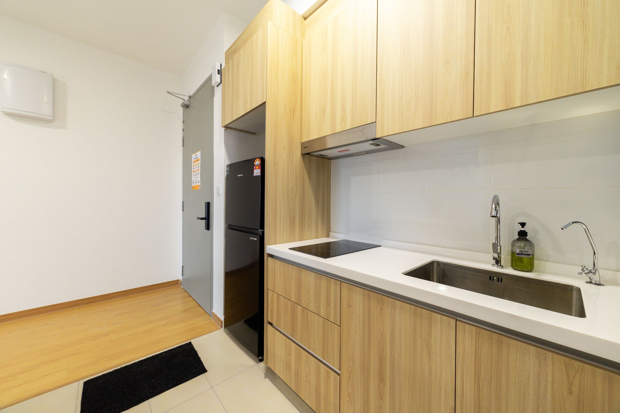 Una cocina moderna con armarios de madera, un lavamanos de acero inoxidable y un horno empotrado.