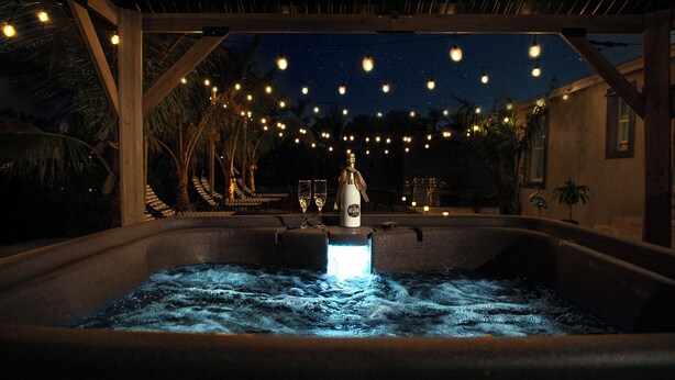 A hot tub with a water fountain feature, surrounded by a wooden pergola and string lights against a night sky. - Charming 3-bedroom villa with AC, WiFi in tranquil Naples (Naples)