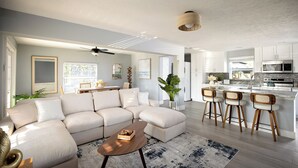 A modern living room with a sectional sofa, a coffee table, and a kitchen area with bar stools. - Charming 3-bedroom villa with AC, WiFi in tranquil Naples (Naples)