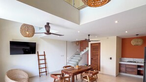 Une cuisine moderne dotée d’une cuisinière intégrée, de meubles en bois et d’un coin repas avec une table et des chaises en bois.