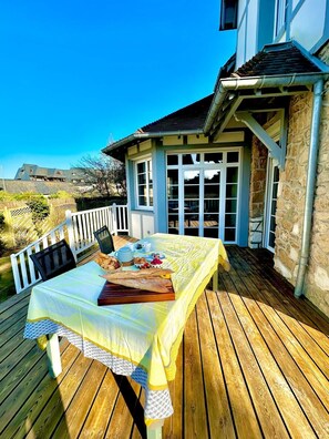 Enjoy a meal on the deck surrounded by a charming garden view.