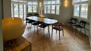 A spacious dining area with a large oval table, multiple chairs, and a wooden herringbone floor. - Dream villa 50 meters from the beach! (Benerville-sur-Mer)