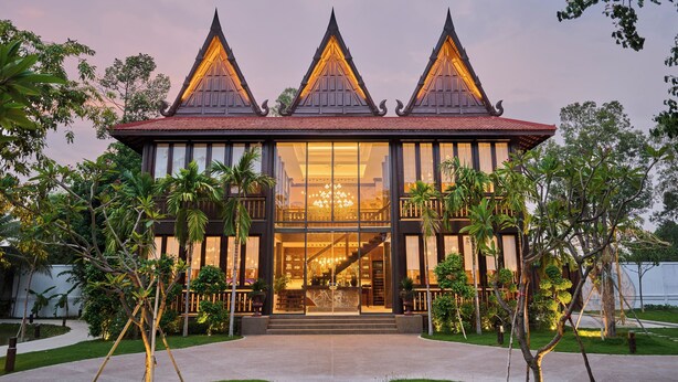 A traditional building with a symmetrical facade, a central staircase, and a well-maintained garden.