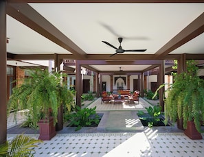 A covered outdoor area with a ceiling fan, seating, and potted plants. - Phoum Chaufea Resort (Siem Reap)
