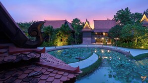 A traditional building with a lotus pond, surrounded by greenery and a twilight sky. - Phoum Chaufea Resort (Siem Reap)