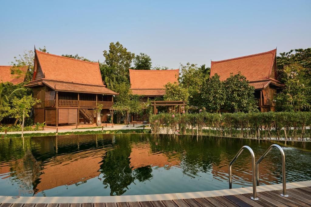 A traditional building with a pool in front.