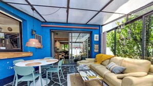 Un rincón interior acogedor con una mesa, sillas, un sofá y una mesita de centro.