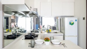 Une cuisine moderne dotée d’un îlot central, d’appareils électroménagers en acier inoxydable et d’un réfrigérateur orné d’un logo.