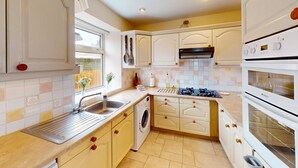 A kitchen with a sink, stove, oven, and a washing machine.