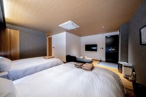 A modern hotel room with two beds, a desk, a flat-screen TV, and a ceiling-mounted air purifier.