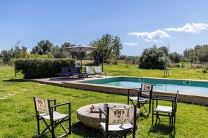 A swimming pool with lounge chairs and a table, surrounded by grass and trees. - Countryside finca in Mallorca with Private Pool and Nature (INCA, Mallorca)