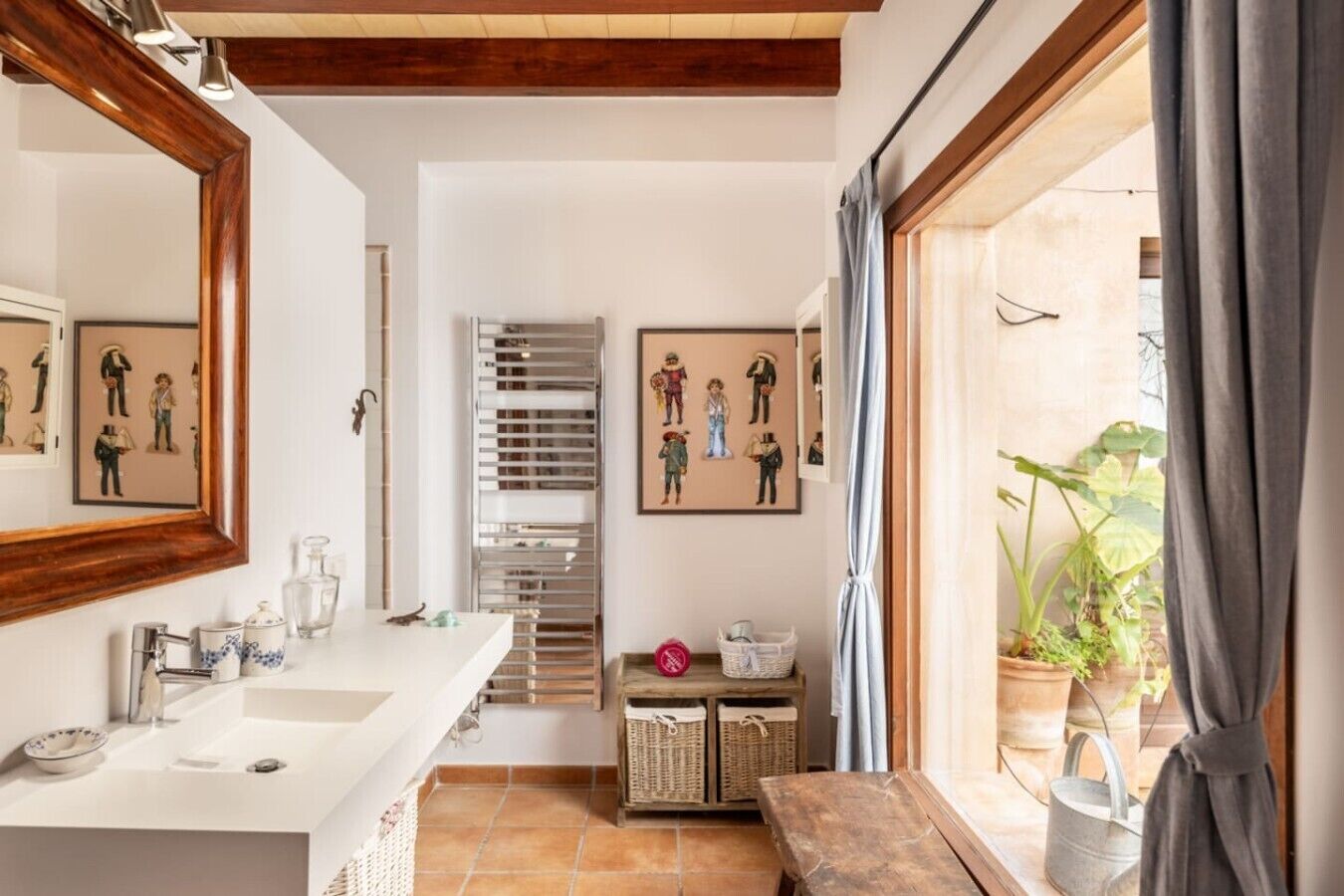 A bathroom with a large mirror, two sinks, a shower, and a window with curtains.