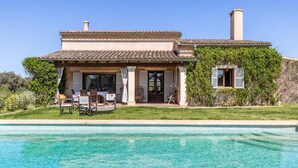 Una casa a due piani con piscina davanti.