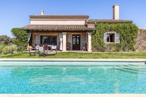 Una casa de dos pisos con una piscina delantera.