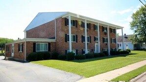 A two-story brick building with a flat roof and a covered front porch. - Oak Overflight Oasis Condo-Minutes to WPAFB & WSU with AC, fast WiFi (Fairborn)