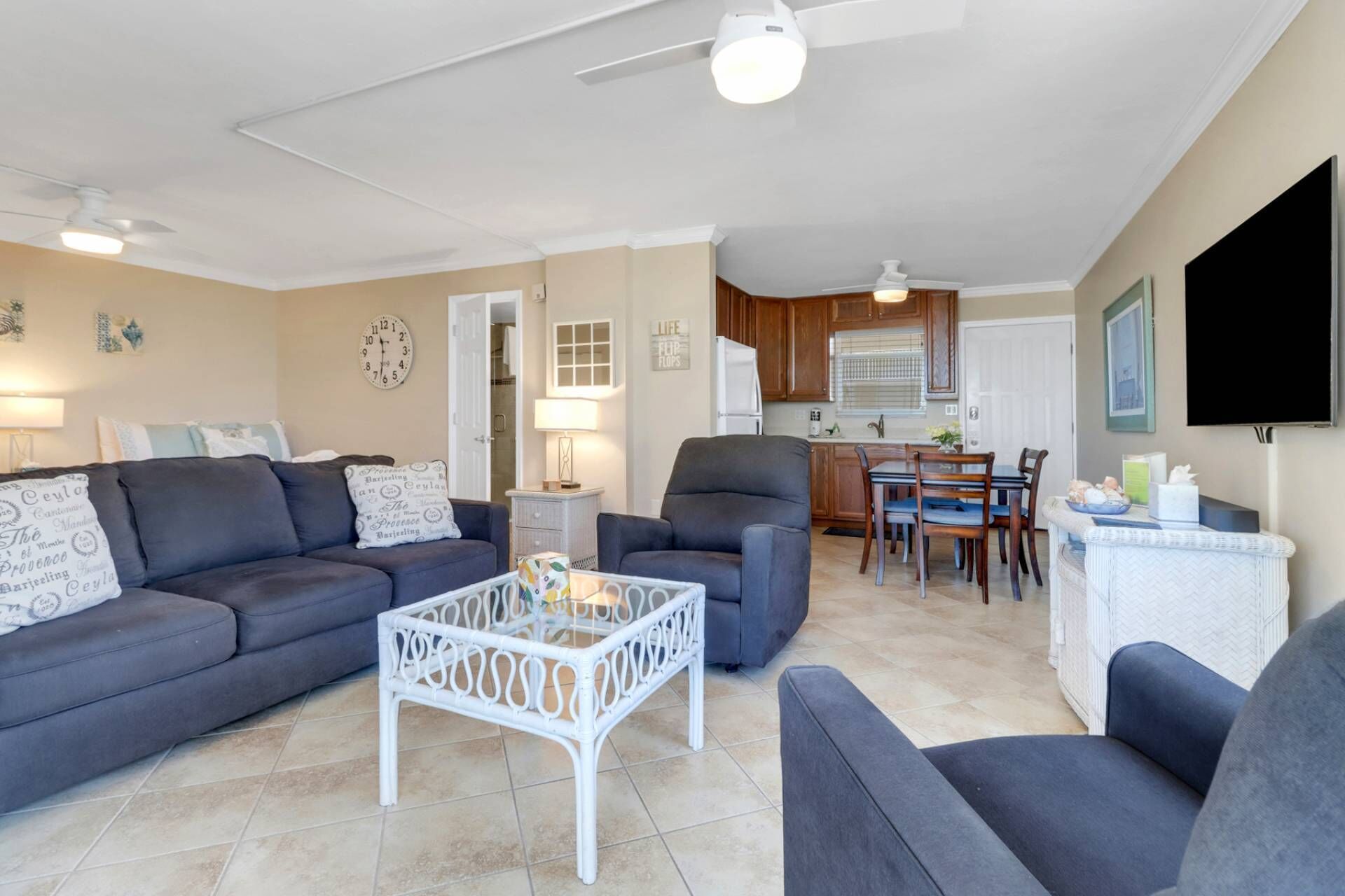 A living room with a sofa, armchairs, a coffee table, and a dining area with a table and chairs.
