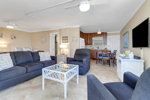 A living room with a sofa, armchairs, a coffee table, and a dining area with a table and chairs.