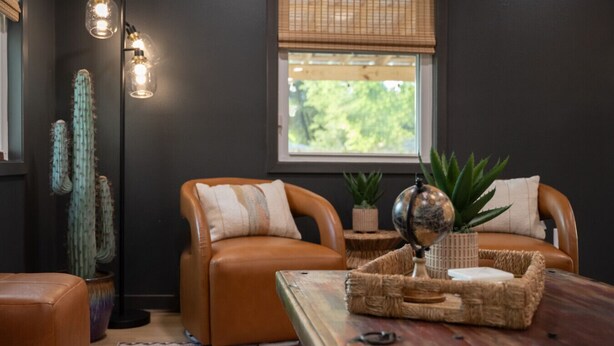 A cozy living room with leather sofas, a wooden coffee table, and a cactus plant. - The Dunn Right - Pool, Game Room, Yard Games, 1.5 Miles to TAMU (Bryan)