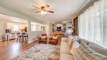 A spacious living area with a sofa, a coffee table, and a ceiling fan.