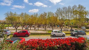 Ein Parkplatz mit mehreren Autos, Bäumen und blauem Himmel.