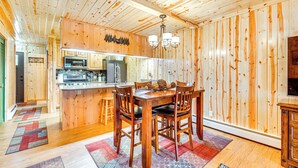Een houten interieur met een eetgedeelte, keuken en een kroonluchter.