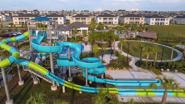 A water park with multiple slides and a pool area, surrounded by residential buildings. - Magical Themed Home with Pool in Top Resort (Davenport)