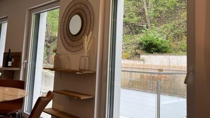Un interior moderno con amplios ventanales, un comedor y estanterías empotradas.