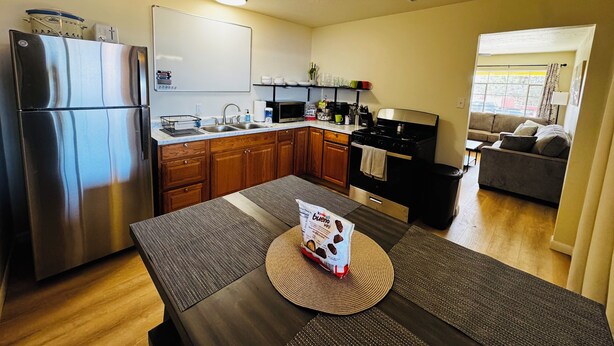 A modern kitchen with a stainless steel refrigerator, wooden cabinets, a microwave, and a stove. - Free Chick-fil-A & Starbucks! 502 Hideaway! (Farmington)