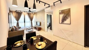 A modern dining area with a table set for four, a ceiling fan, and a large window with curtains. - Gaia Residences by Sleepy Bear (Rawang)