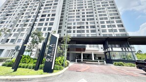 A high-rise residential building with a modern design, featuring a prominent entrance with a gated driveway and landscaped surroundings. - Gaia Residences by Sleepy Bear (Rawang)