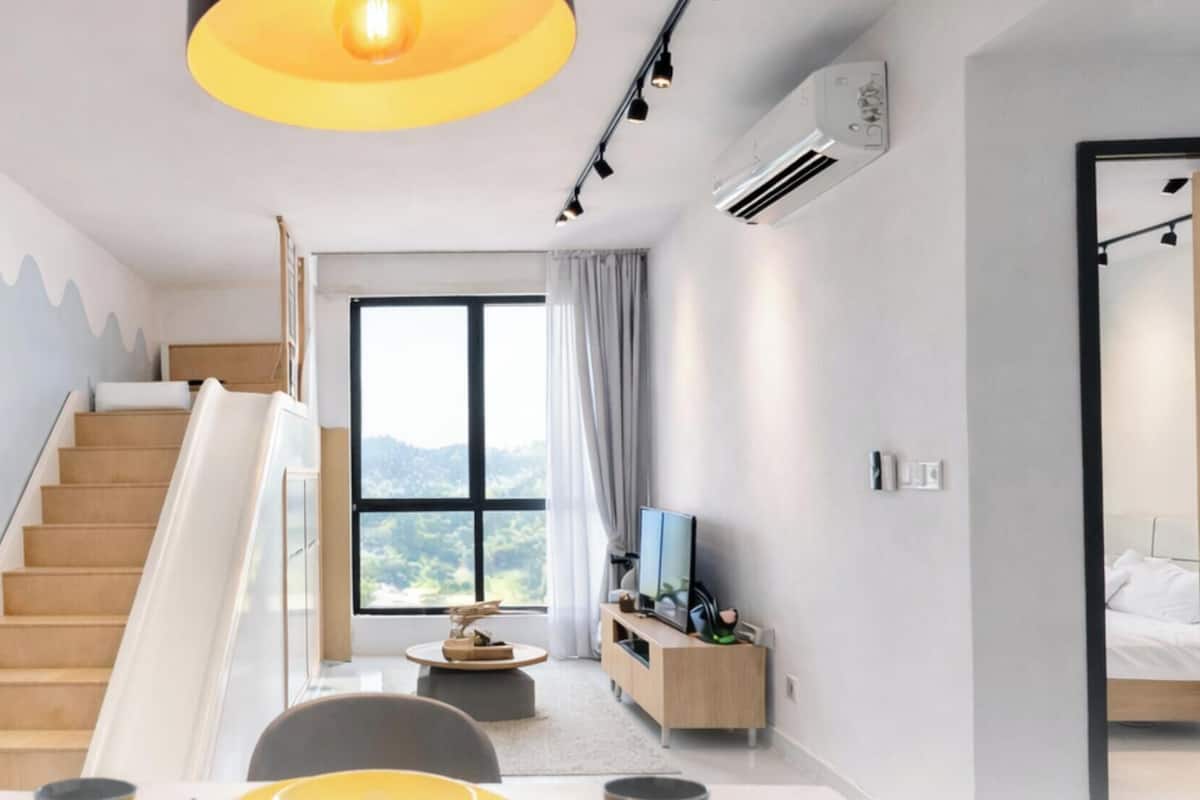 Een moderne hotelkamer met een trap, een eethoek, een televisie en een groot raam met uitzicht.