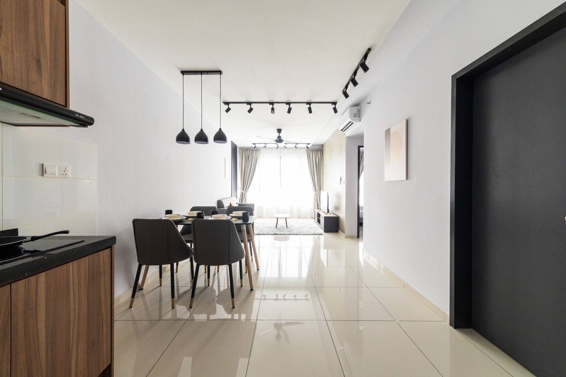 Una cocina moderna con comedor, que presenta una encimera negra, armarios de madera y un ventilador de techo.