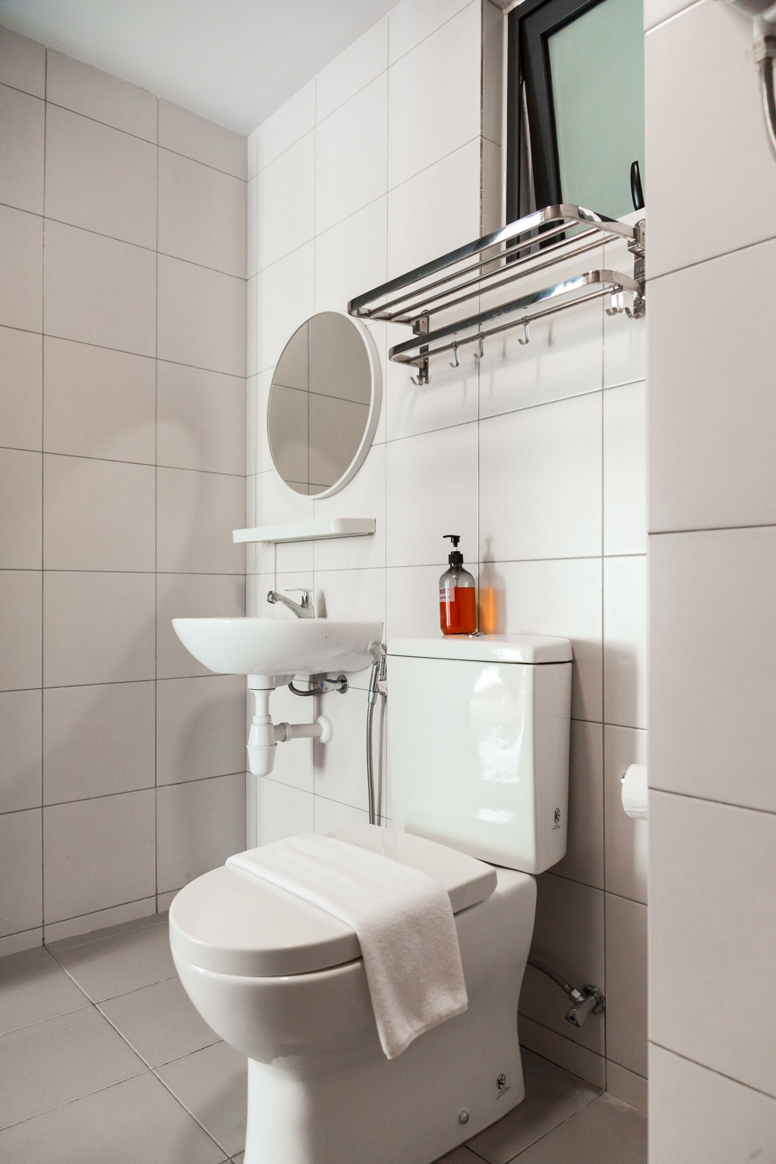 Een moderne badkamer met toilet, wastafel en spiegel.