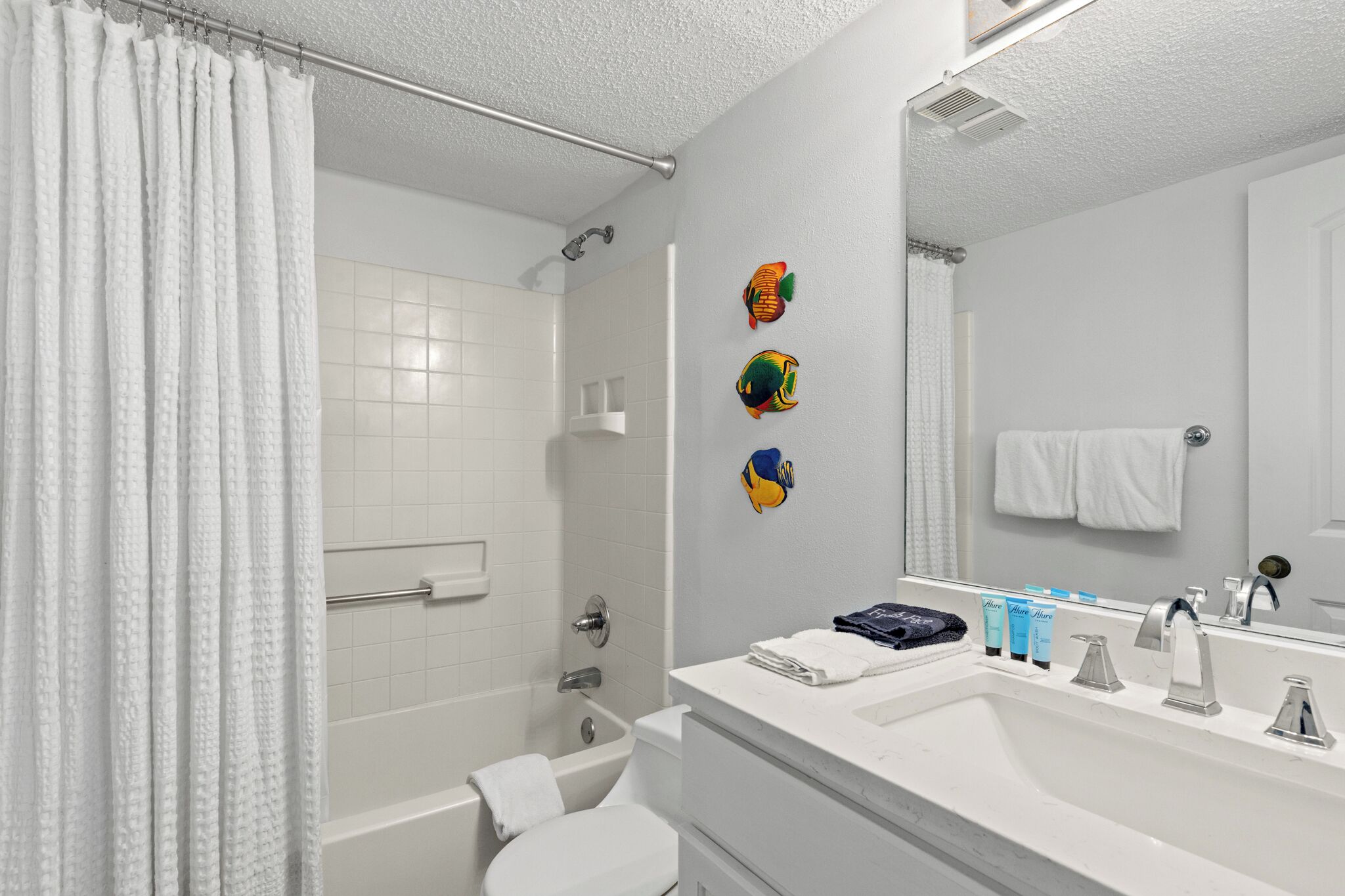 A bathroom with a bathtub, toilet, sink, and a shower curtain.